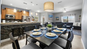 A modern kitchen with granite countertops, stainless steel appliances, and pendant lighting. - Zairytale Candy Luxury 5BR, 4BA with Pool in Kissimmee (Kissimmee)
