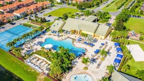 An aerial view of a resort with a large swimming pool, multiple lounge areas, and a well-maintained lawn. - Zairytale Candy Luxury 5BR, 4BA with Pool in Kissimmee (Kissimmee)