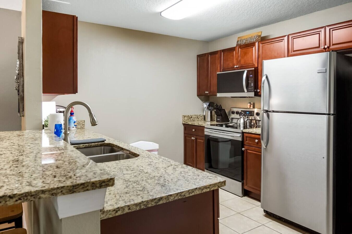 A kitchen with granite countertops, stainless steel appliances, and wooden cabinets.