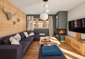 A modern living room with a sectional sofa, a fireplace, and a television.