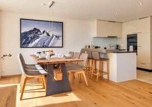 Una cocina moderna con comedor, que incluye una mesa de madera, sillas y una isla de cocina.