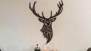 A dining table set with plates, glasses, a coffee pot, and a decorative deer head on the wall. - Luxury Apartment, 3 Bedrooms with Jacuzzi Chalet Rahas A Grimentz - By Mrs Miggins (Grimentz)