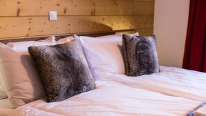 A bed with white linens and two large, dark gray pillows. - Luxury Apartment, 3 Bedrooms with Jacuzzi Chalet Rahas A Grimentz - By Mrs Miggins (Grimentz)