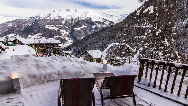 Ein mit Schnee bedeckter Außenbereich mit Blick auf schneebedeckte Berge.