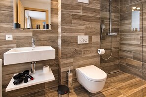 Un baño moderno con lavamanos, inodoro y ducha.