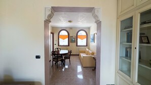 A hallway with a dining area, a sofa, and a bookcase. - Appartamento a cannaregio by Ca-Sa Check (Venice)