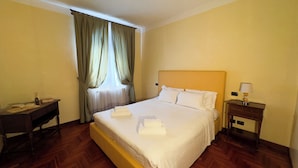 A hotel room with a large bed, a bedside table with a lamp, and a window with curtains. - Appartamento a cannaregio by Ca-Sa Check (Venice)
