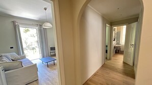 A spacious living area with a sofa, a small table, and a view of the outdoors. - Oleandri cosy Apartment Near best beaches (Monterosso al Mare)