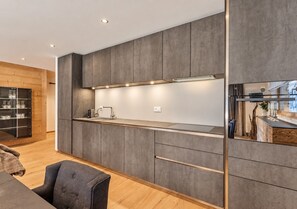 Et moderne køkken med indbyggede skabe, en bordplade og en indbygget ovn.