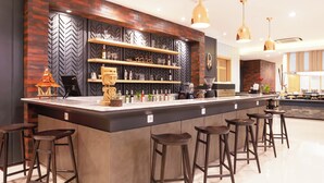 A modern kitchen with a central island, bar stools, pendant lighting, and built-in shelves. - Best Western Sagita Hotel Jayapura (Jayapura)