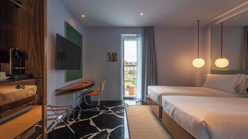 A modern hotel room with a large bed, a desk, a chair, a TV, and a view of the outside.