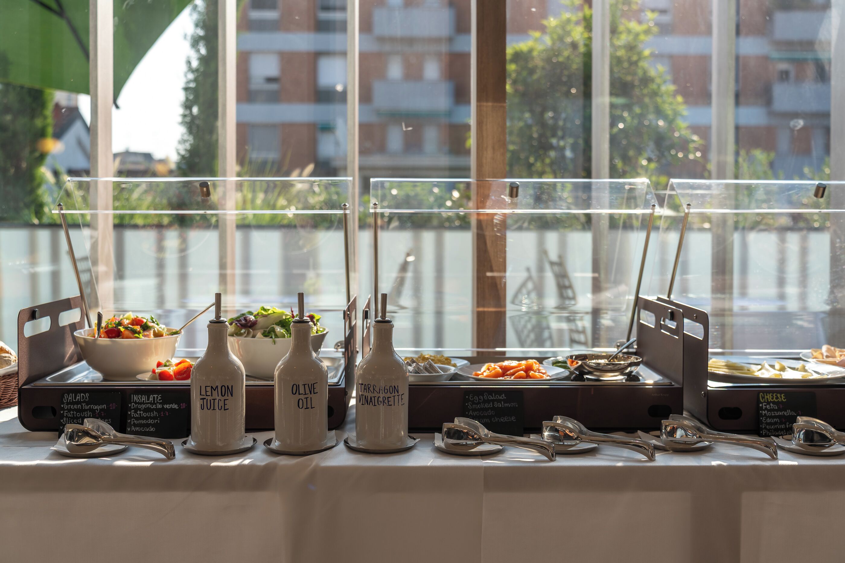 Un buffet proposant une variété de plats et des distributeurs d’assaisonnements clairement étiquetés.