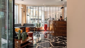 A modern lobby with a glass partition, seating area, and a reception desk. - Hotel Calimala Milano (Milan)