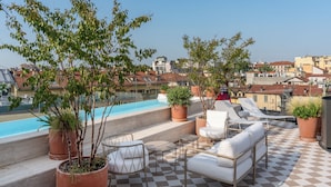 A rooftop terrace with a pool, outdoor seating, and potted plants. - Hotel Calimala Milano (Milan)
