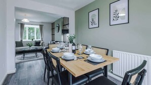 A dining area with a wooden table set for four, surrounded by black chairs. - Stunning Home, Ideal for Business, FREE Parking! (Greater Manchester)