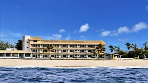 A beachfront hotel with multiple floors, a beach in front, and palm trees. - Imperial Arembepe Beach Hotel (Camaçari)