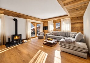 A modern living room with a fireplace, a sofa, a coffee table, and a wooden floor.