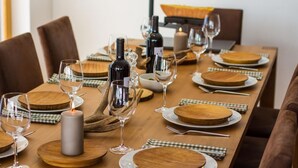 A dining table set with wine glasses, plates, and a candle. - Duplex de Luxe, 5 chambres Rahas A Grimentz - By Mrs Miggins (Grimentz)