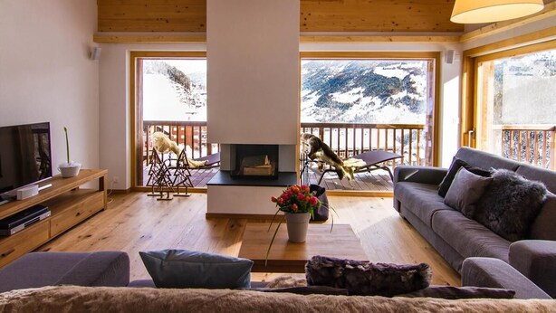 A cozy living room with a fireplace, wooden floors, a sofa, and a TV. - Duplex de Luxe, 5 chambres Rahas A Grimentz - By Mrs Miggins (Grimentz)