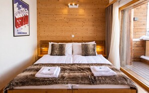A wooden-paneled room with a bed, pillows, and a poster on the wall.