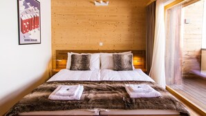 A wooden-paneled bedroom with a bed, pillows, and a fur throw. - Duplex de Luxe, 5 chambres Rahas A Grimentz - By Mrs Miggins (Grimentz)