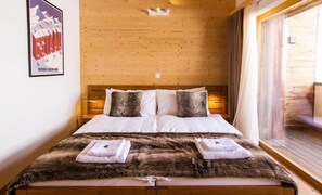 A wooden-paneled bedroom with a bed, pillows, and a fur throw. - Duplex de Luxe, 5 chambres Rahas A Grimentz - By Mrs Miggins (Grimentz)