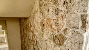 A staircase with a stone wall on one side and a marble floor.