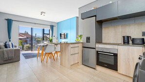 Eine moderne Küche mit Kühlschrank, Backofen und Kaffeemaschine.