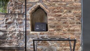 Un mur en pierre agrémenté d’un banc intégré et d’une petite alcôve abritant un panneau de commande.