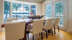 Un coin repas avec une table en bois, quatre chaises et un bol décoratif posé sur la table.