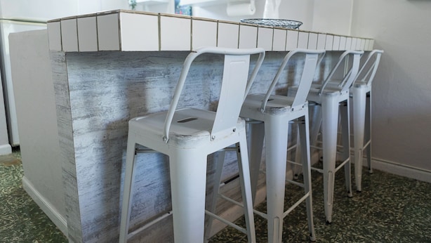 A kitchen with a white countertop and bar stools. - Vintage Modern GEM in the Heart of Santurce w/parking (San Juan)