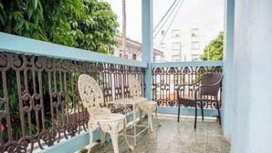 A balcony with a blue railing, two white chairs, and a black chair. - Vintage Modern GEM in the Heart of Santurce w/parking (San Juan)