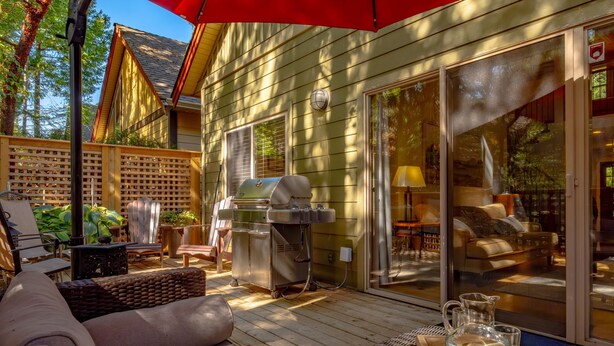 A patio with outdoor furniture, a grill, and a sliding glass door leading to an interior living area.