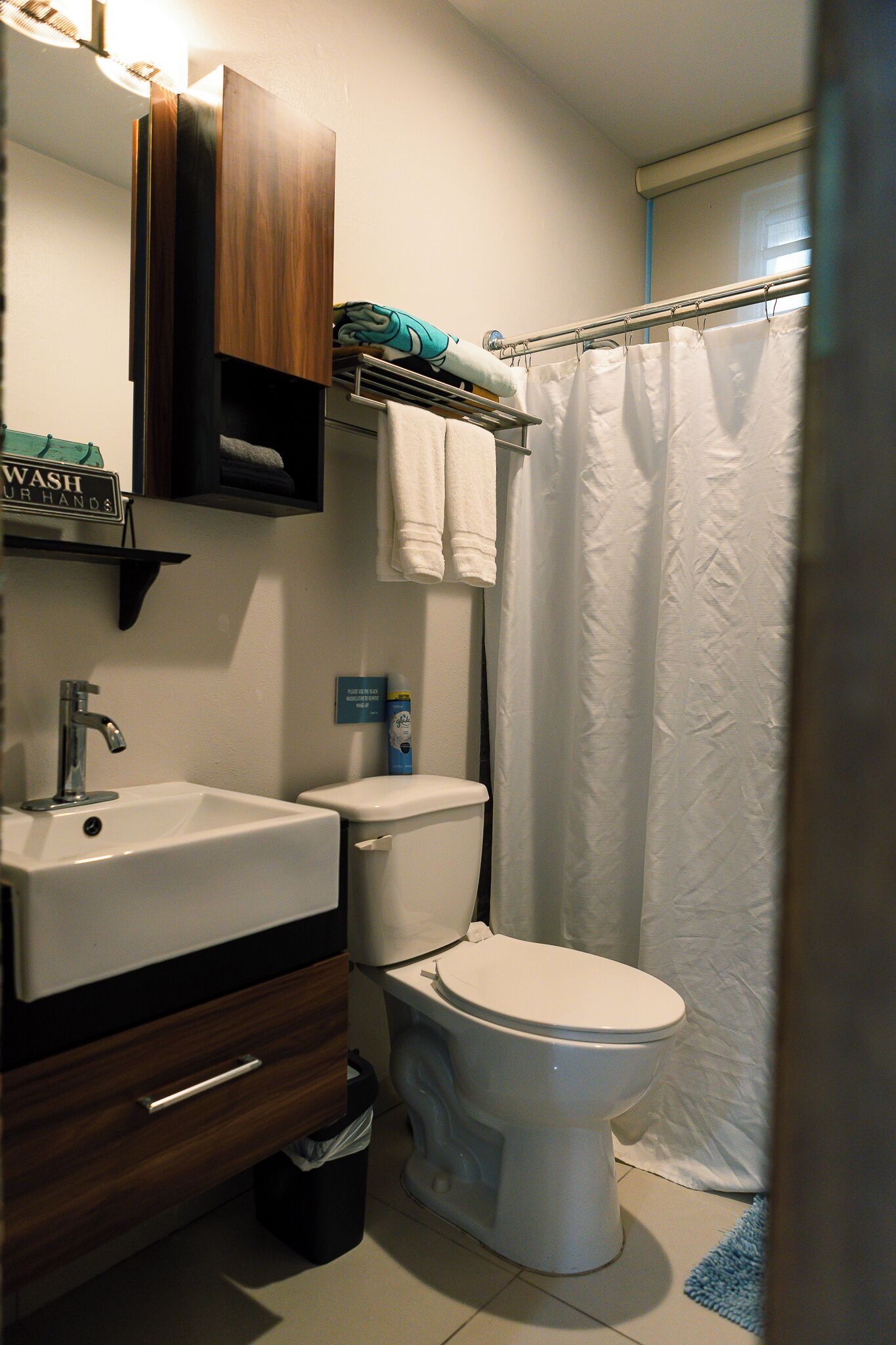 A bathroom with a sink, toilet, and a shower curtain.