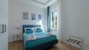 Una camera da letto moderna con un letto grande, un tavolino rotondo e una panca vicino alla finestra.