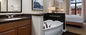 A hotel bathroom with a sink, vanity, bathtub, and a bed. - Great Smokies Lodge 1 Bedroom Deluxe! (Sevierville)