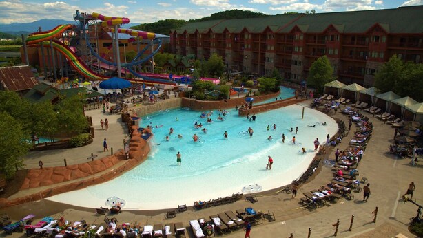 A hotel with a large pool area, a water park, and a building with multiple balconies. - Great Smokies Lodge 1 Bedroom Deluxe! (Sevierville)