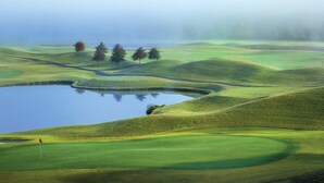 A golf course with rolling green hills, a pond, and a few trees. - Great Smokies Lodge 1 Bedroom Deluxe! (Sevierville)