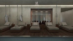 Een moderne spa-ruimte met zes comfortabele stoelen, een houten vloer en een glazen scheiding die de ruimte van een zwembadgedeelte afscheidt.