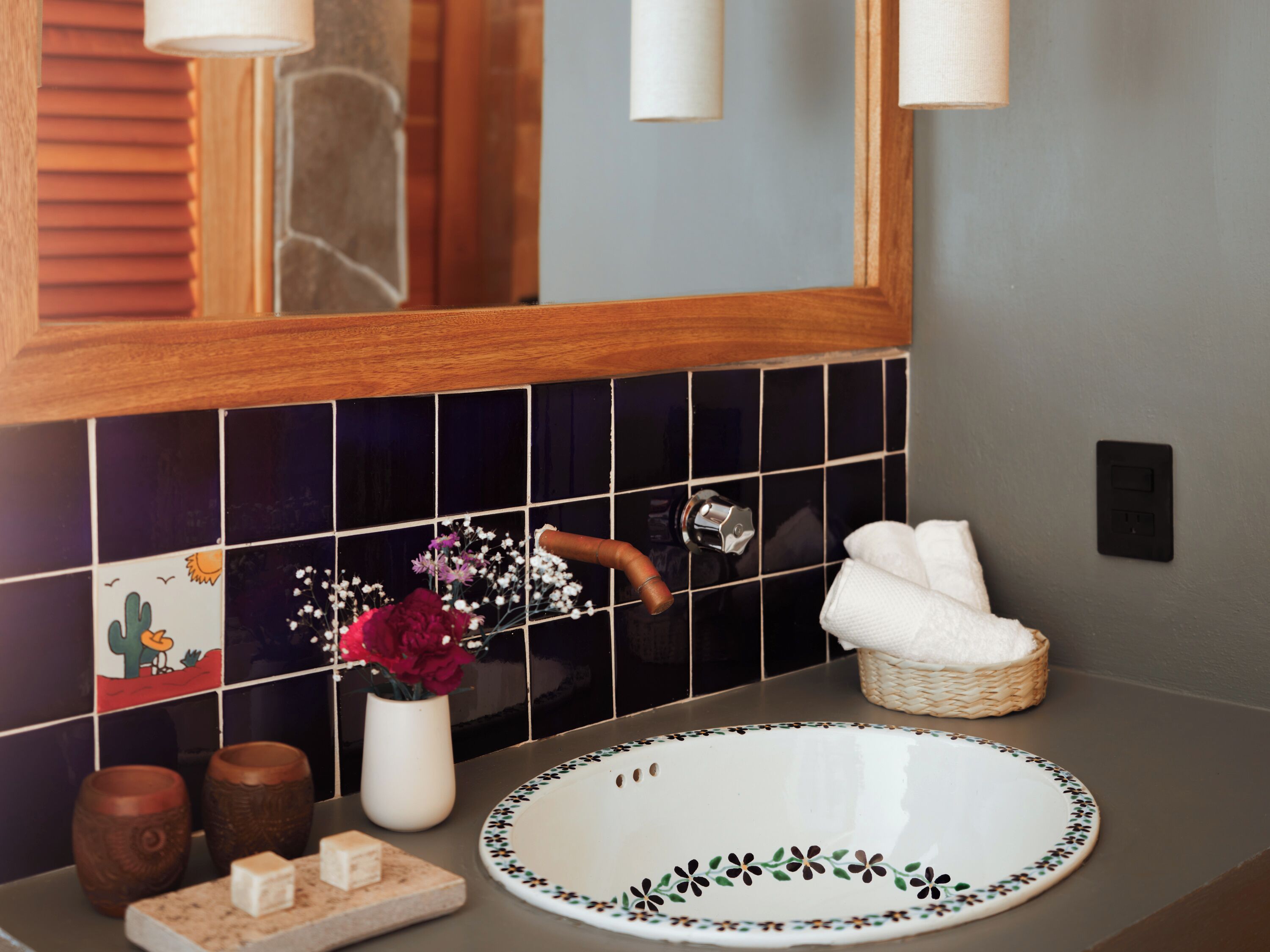 A bathroom with a white sink, a mirror, and a tiled backsplash.
