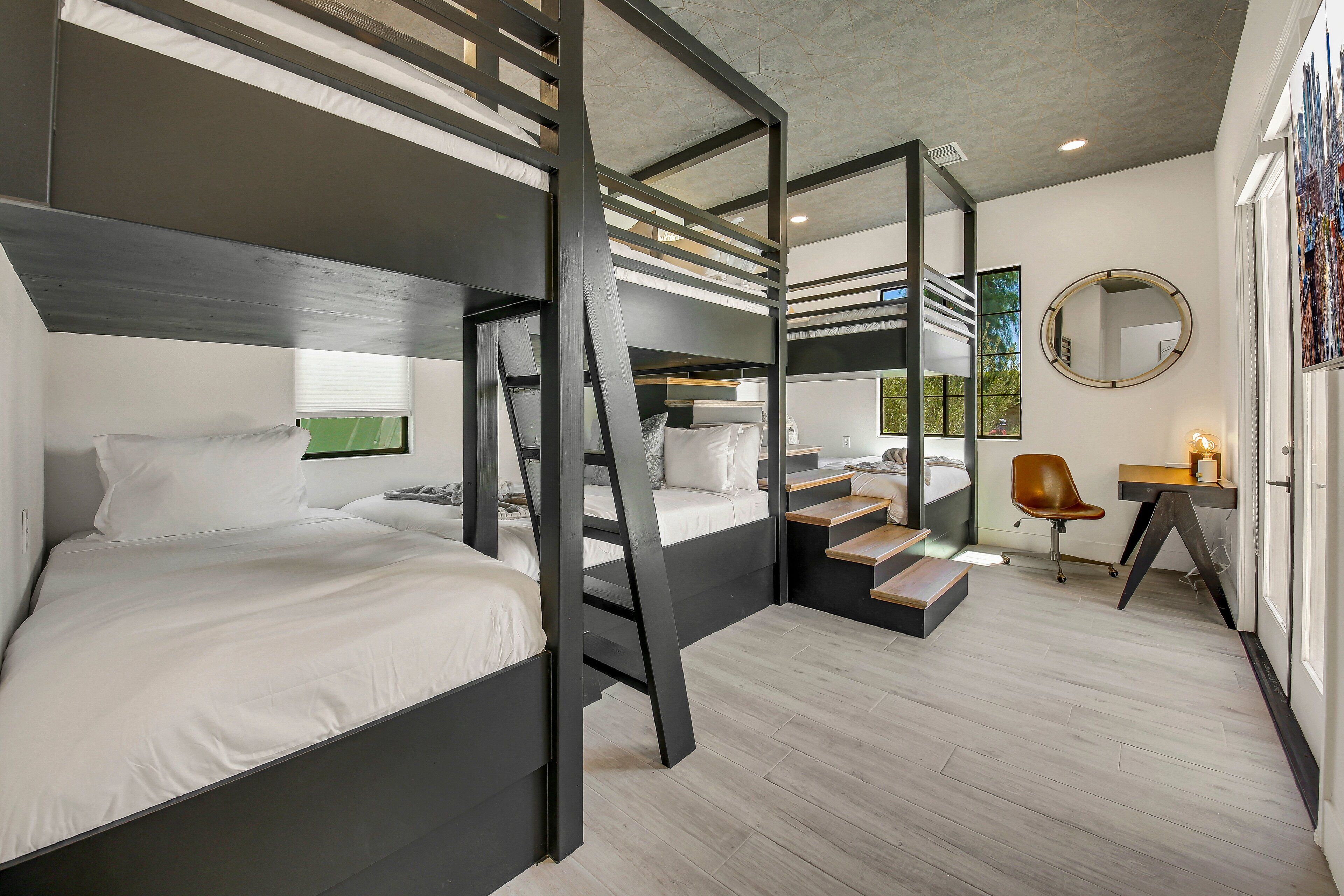 Una camera da letto moderna con letti a castello, una scrivania e uno specchio.