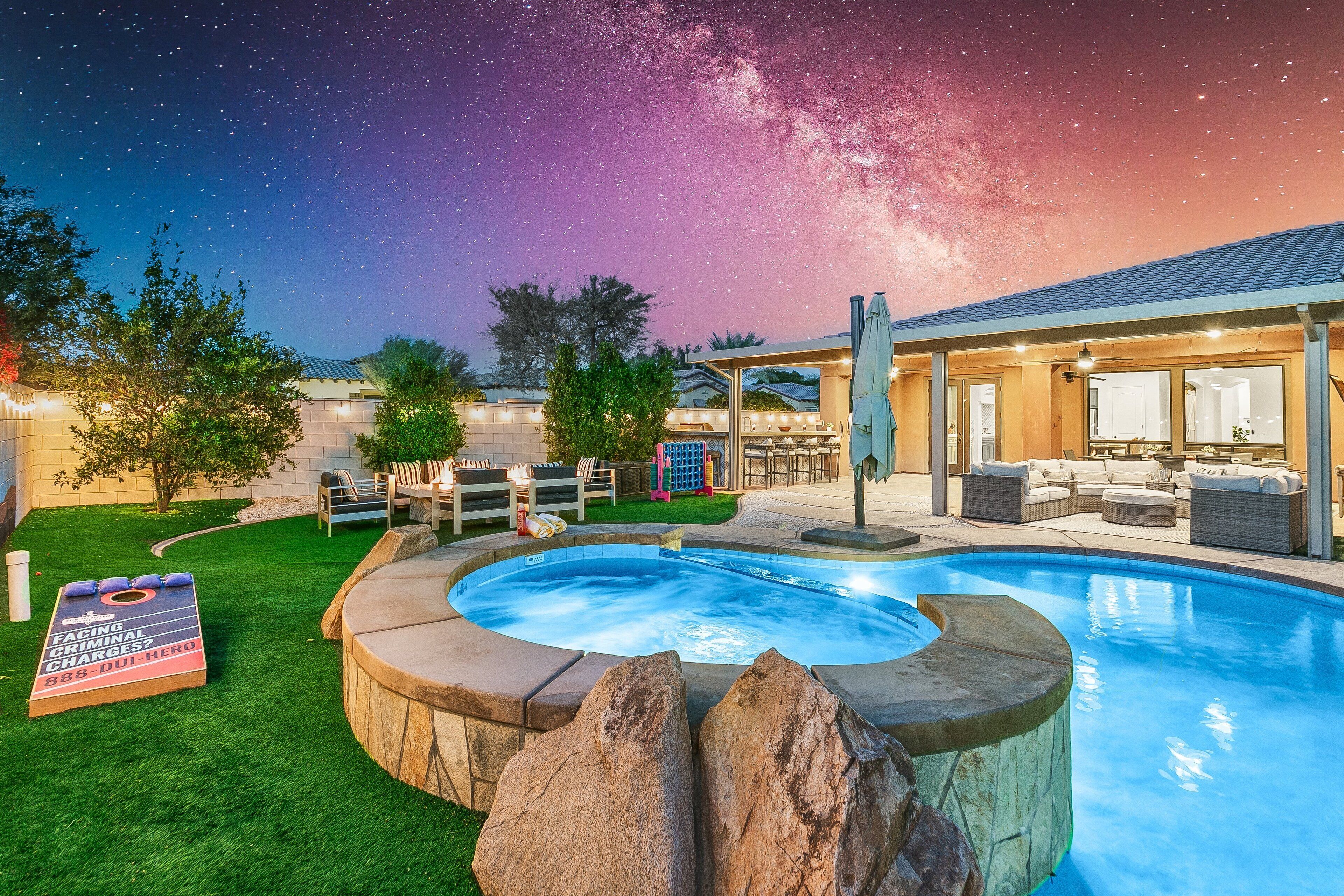 En baghave med swimmingpool, jacuzzi og et spilbord.