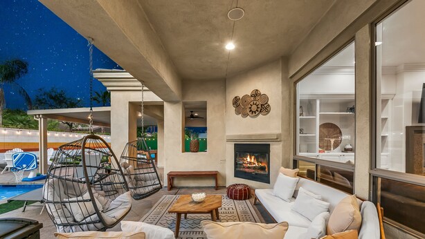 A spacious outdoor living area with a pool, lounge chairs, a sofa, and a fireplace. - Wilder Out West: Luxury Pickleball, Mini Golf, & Game Room! (Indio)