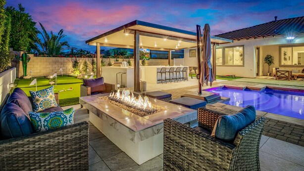 A poolside area with a fire feature, outdoor seating, and a covered patio. - The Montage Resort (Indio)