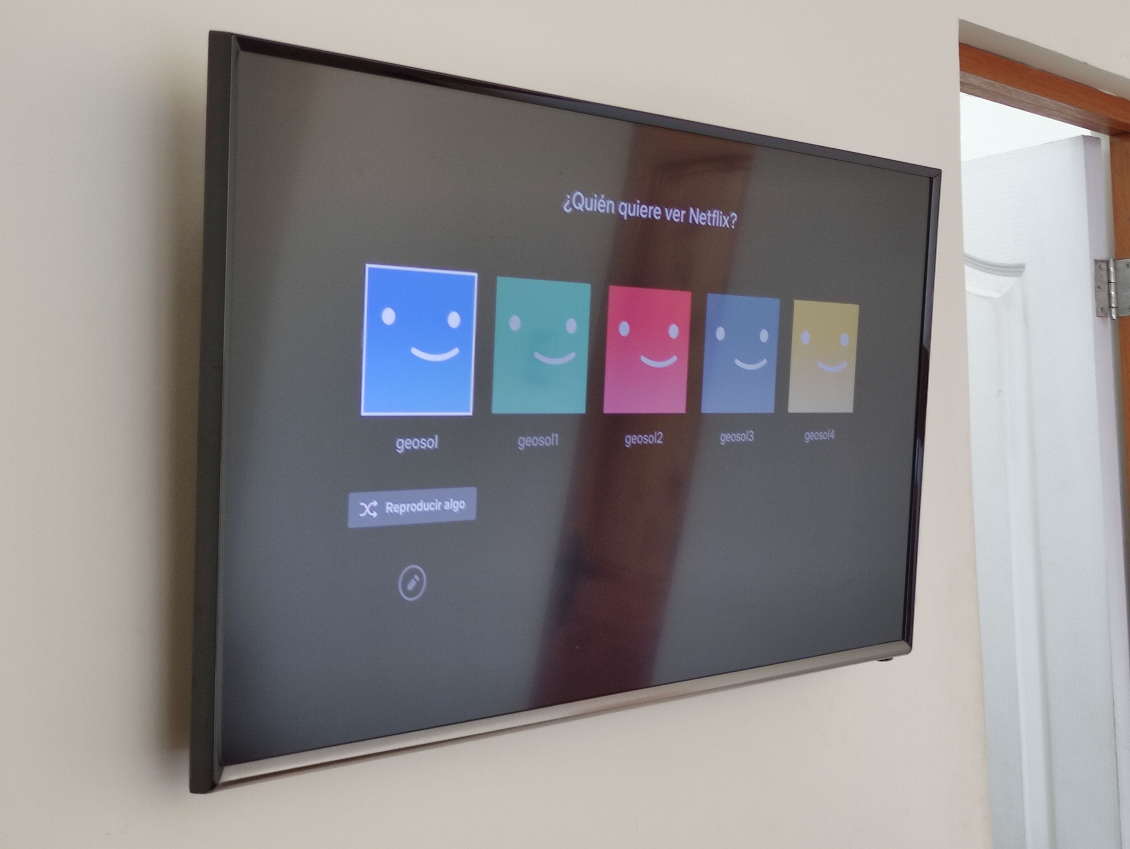 Un écran fixé au mur affiche une sélection d’options Netflix et propose une question du type : « Qui veut regarder Netflix ? »