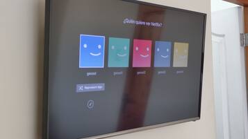 Un écran fixé au mur affiche une sélection d’options Netflix et propose une question du type : « Qui veut regarder Netflix ? »