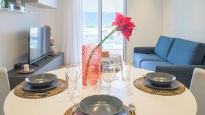 A dining table set with bowls, glasses, and a vase with a red flower. - Porta del Mare Luxury Apartment (Salerno)