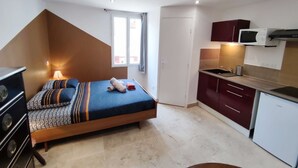 A compact room with a bed, a small kitchenette, and a window. - Studio Caesar - Air conditionning (Arles)