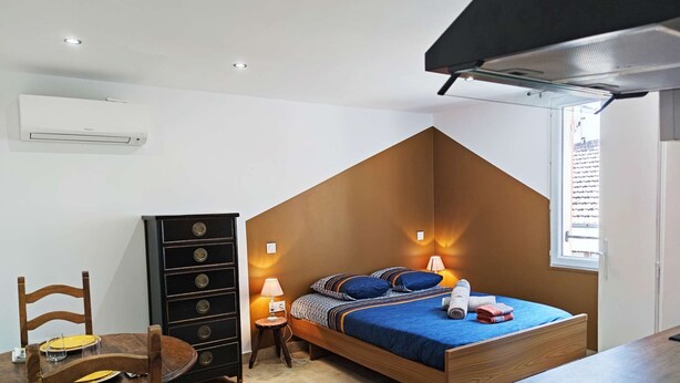 A bedroom with a bed, a dresser, a chair, and a window. - Studio Caesar - Air conditionning (Arles)
