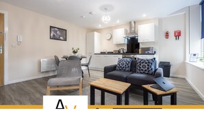 A modern living room with a grey sofa, a wooden coffee table, and a laptop.
